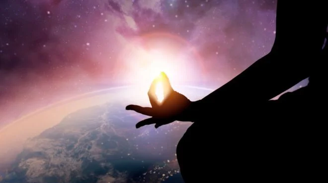 Silhouette of a meditating man above the Earth, symbolizing spiritual enlightenment and connection with higher realms.